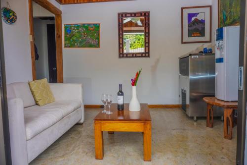 a living room with a couch and a table at La Fortuna Lodge by Treebu Hotels in Fortuna