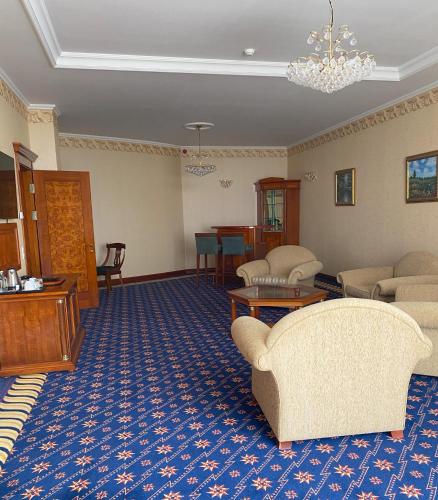 a living room with couches and a blue carpet at Hotel Golden Palace in Göd