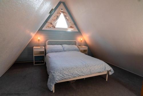 um quarto no sótão com uma cama e duas mesas de cabeceira em Chalet Fortysix em Deal