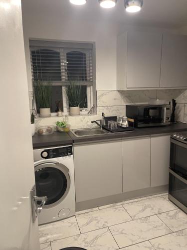 a kitchen with a washing machine and a sink at Inviting 1-Bed Apartment in London in London