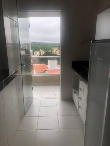 a kitchen with a glass door and a window at Flat Vereda, 524 -Rio quente. in Rio Quente