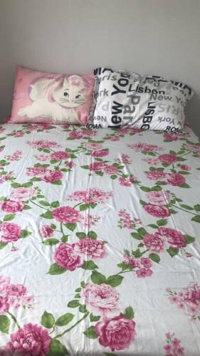 a bed with pink flowers on top of it at Flat Vereda, 524 -Rio quente. in Rio Quente