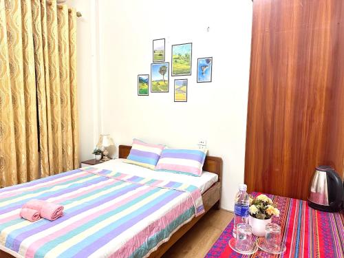a small bedroom with a bed and a table at Huong Thao Hostel & Tours in Dien Bien Phu