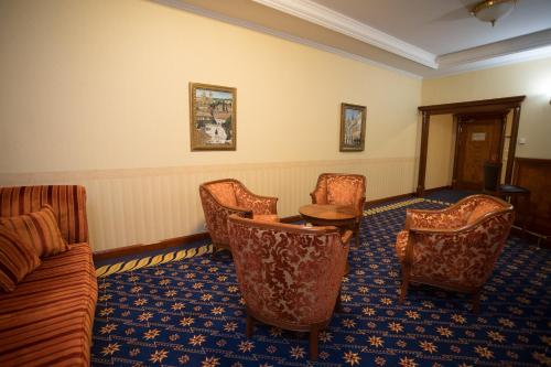 a room with chairs and a table and a couch at Hotel Golden Palace in Göd
