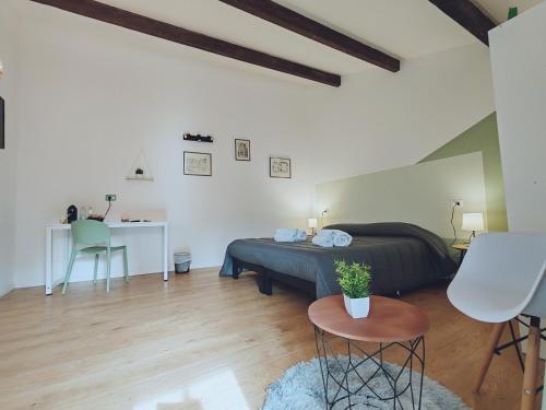 um quarto com uma cama, uma mesa e uma cadeira em Alilè em Sassari