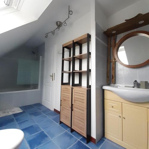 une salle de bain avec un lavabo et un miroir dans l'établissement Les moussaillons, Les gîtes de Tréguennec, à Tréguennec