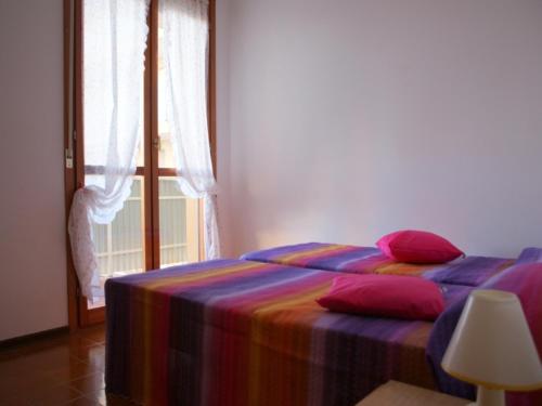 - une chambre avec un lit et une couverture colorée dans l'établissement Cozy apartment in elegant resort - Beahost, à Bibione