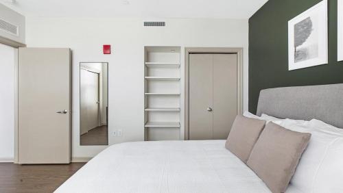 1 dormitorio con cama blanca y espejo en Landing - Modern Apartment with Amazing Amenities (ID9312X01) en Detroit