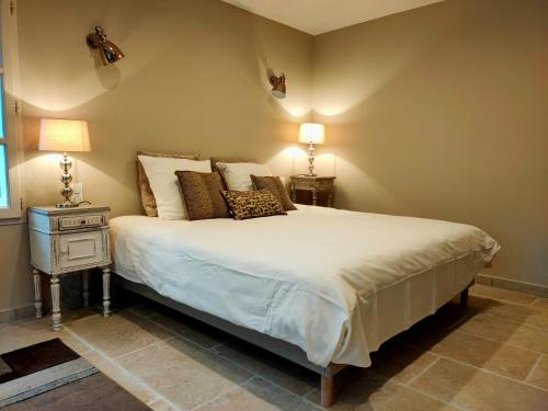 a bedroom with a bed and a nightstand with two lamps at Le mas de Roussillon chambre d'hôtes in Roussillon