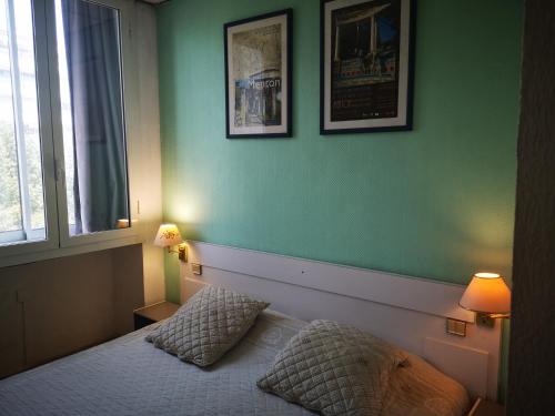 a bedroom with a bed with two pillows and a window at Hôtel Claridge's in Menton