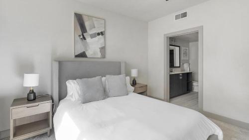 um quarto branco com uma cama e uma casa de banho em Landing - Modern Apartment with Amazing Amenities (ID9504X23) em Plano