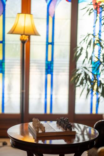 a table with a lamp and a chess board on it at Hotel Golden Palace in Göd