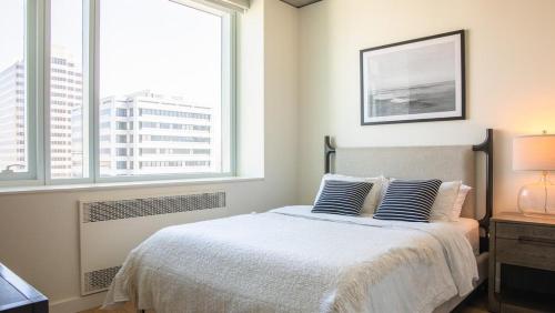1 dormitorio con 1 cama con 2 almohadas y 2 ventanas en Landing Modern Apartment with Amazing Amenities (ID2480X10), en Oakland