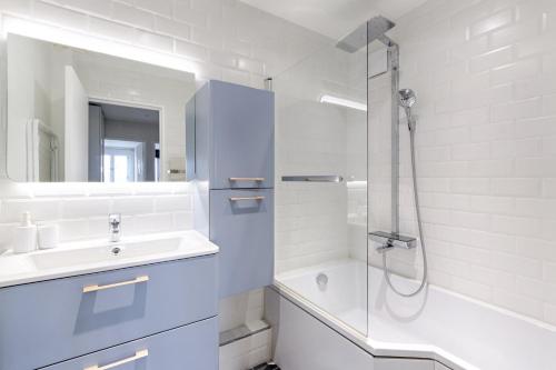 biała łazienka z umywalką i prysznicem w obiekcie Résidor - Warm and bright 6P apartment! w Paryżu