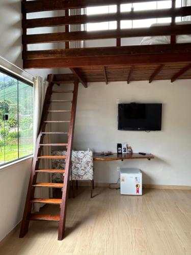 Zimmer mit einem Loft mit einem Schreibtisch und einem TV in der Unterkunft Castelo fort in Caparaó Velho