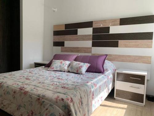 1 dormitorio con 1 cama y pared de madera en Lujoso, confortable y hermoso Apto en Funza,, en Funza