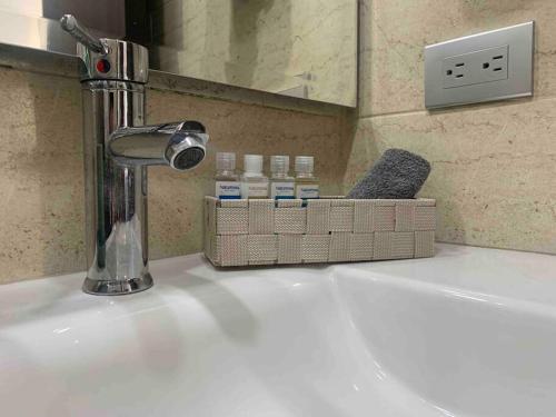 un lavandino in bagno con rubinetto e bottiglie sopra di Lujoso, confortable y hermoso Apto en Funza, a Funza