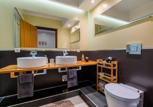 a bathroom with two sinks and a toilet at Saudades do Sol y Mar Apartment in Lagoa