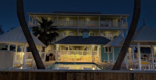 a large house with a swimming pool in front of it at Seashell Village Resort near the beach with kitchens in Port Aransas