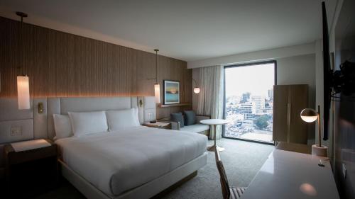 une chambre d'hôtel avec un lit et une grande fenêtre dans l'établissement Courtyard by Marriott Santo Domingo Piantini, à Saint-Domingue