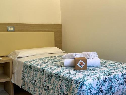 Un dormitorio con una cama con una caja. en Villetta con vista mare e parcheggio en Isola del Giglio