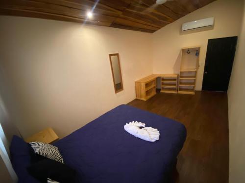 a bedroom with a bed with a blue blanket at Grand Park Manuel Antonio - Adults Only in Manuel Antonio