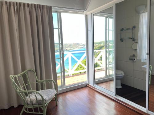 a bathroom with a toilet and a balcony at Bay House Grenada in Belmont