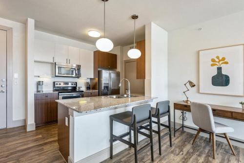 een keuken met een bar met stoelen en een tafel bij Landing - Modern Apartment with Amazing Amenities (ID1403X885) in Atlanta