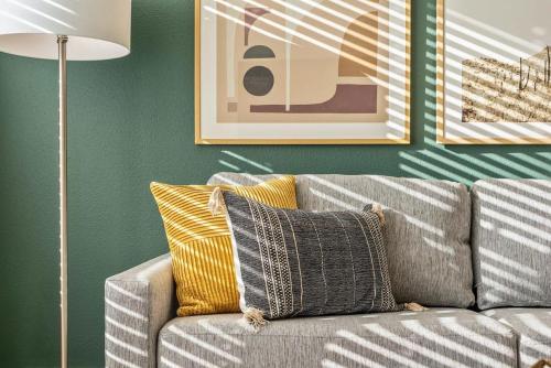een woonkamer met een grijze bank en gele kussens bij Landing - Modern Apartment with Amazing Amenities (ID1403X885) in Atlanta