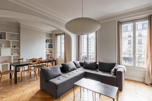 un salon avec un canapé et une table dans l'établissement Appartement Palido - Welkeys, à Paris