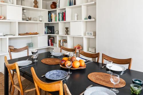 une salle à manger avec une table et des chaises noires dans l'établissement Appartement Palido - Welkeys, à Paris