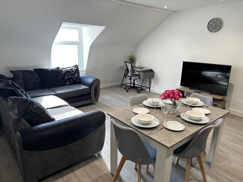 uma sala de estar com uma mesa e um sofá em El Murrino Apartments em Bournemouth