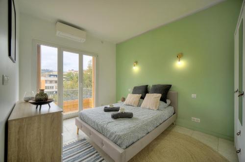 um quarto com uma cama e uma grande janela em Téry - Terrasse - Moderne - VCA em Cannes