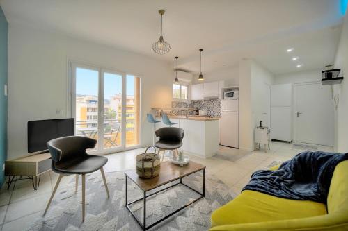 uma sala de estar com um sofá e cadeiras e uma cozinha em Téry - Terrasse - Moderne - VCA em Cannes