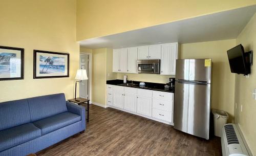 a kitchen with a blue couch and a refrigerator at Seashell Village Resort near the beach with kitchens in Port Aransas