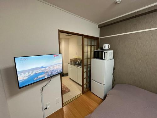 a room with a flat screen tv on a wall at 玉藻藤塚町 in Takamatsu
