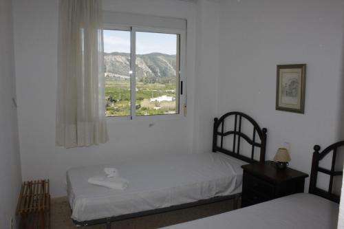 um quarto com 2 camas e uma janela em Mar Azul Solo Familias Serviplaya em Casas Las Basas