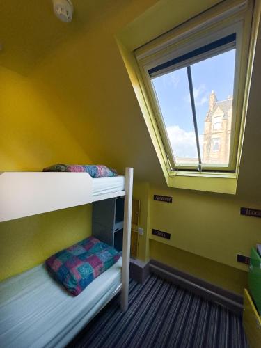 a room with two bunk beds and a window at Castle Rock Hostel - Adults Only in Edinburgh
