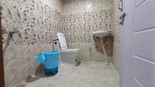 een kleine badkamer met een toilet en een wastafel bij The Hostelers Homestay - Near ISBT, Bypass, Advance Study and HPU Simla in Shimla