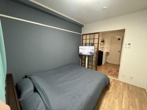 a bedroom with a bed and a flat screen tv at 玉藻藤塚町 in Takamatsu