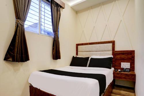 a bedroom with a large bed and a window at OYO Flagship Hotel Ashirwad Inn in Mumbai