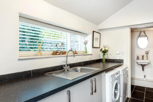 a kitchen with a sink and a window at Moonrakers in Malborough