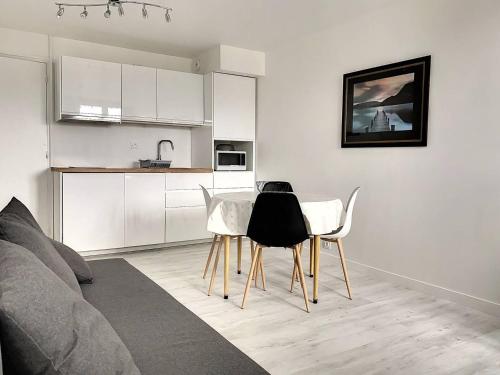 - une cuisine avec une table et des chaises dans le salon dans l'établissement 106 - Appartement rénové Sables d'Or Les Pins, à Fréhel