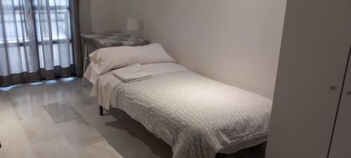 a small bedroom with a bed and a table at Hostel Central Sevilla in Seville