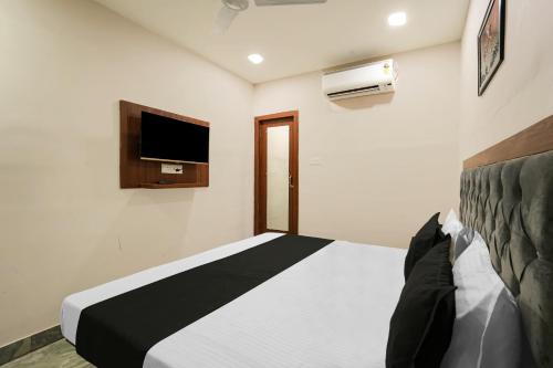 a bedroom with a bed and a flat screen tv at OYO 82256 Hotel 81 Tristar in Bankipur