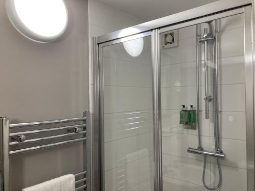 a shower with a glass door in a bathroom at The Lobster in Sheringham