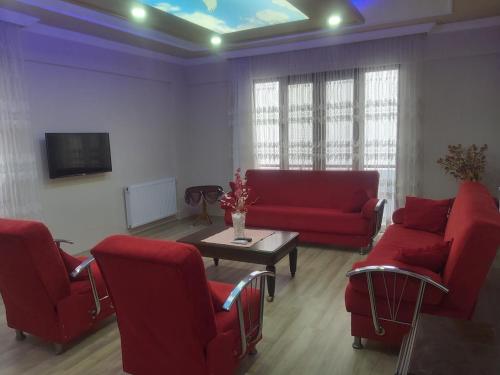 ein Wohnzimmer mit einem roten Sofa und Stühlen in der Unterkunft Sumgayit apart in Cayeli