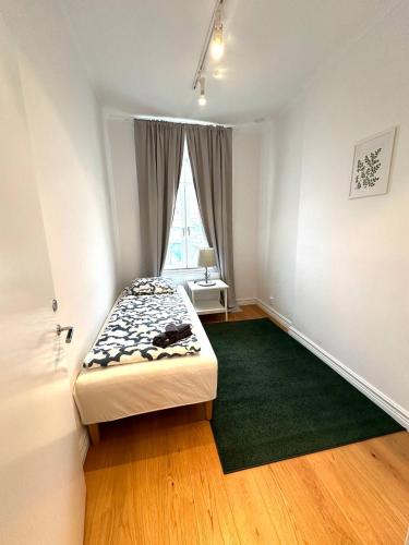 una piccola camera con letto e finestra di Luxury Apartment In City a Göteborg