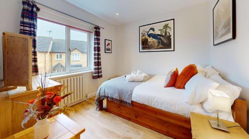a bedroom with a bed and a large window at Cherry Tree Cottage in Bicester