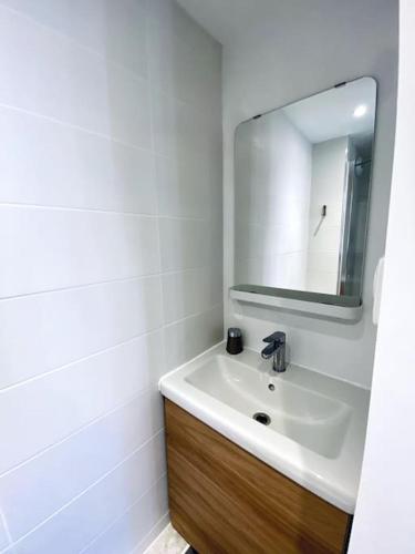 une salle de bain blanche avec un lavabo et un miroir dans l'établissement Studio centre, calme, vrai cocon., à Toulouse